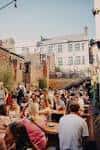 Terraza exterior de un lugar de eventos con personas sentadas en mesas al aire libre