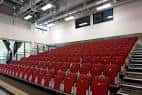 Interior del auditorio con filas de butacas rojas y escenario en primer plano