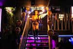 Interior del Soul Lounge con una mujer en el escenario y luces de neón