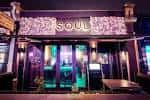 Fachada nocturna del Soul Lounge con letrero iluminado