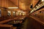 Interior del bar con iluminación cálida y barra de madera