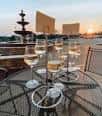 Terraza exterior con copas de vino y fuente decorativa al atardecer