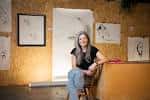 Espacio interior del club con paredes decoradas con bocetos y una persona sentada en un ambiente creativo