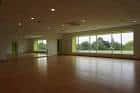 Sala de baile con suelo de madera y grandes ventanales