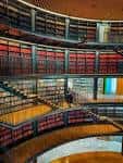 Interior de la biblioteca con estanterías curvas y múltiples niveles iluminados