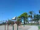Área de juegos al aire libre en Falcon Park con columpios y sombra