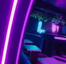 Interior del club con iluminación neón y ambiente nocturno