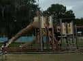 Estructura de juego al aire libre con tobogán curvo y escaleras en Plymouth Playground