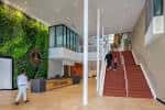 Interior moderno del City Center con escalera roja y pared verde viva