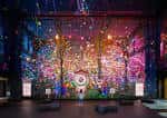 Interior del espacio Outernet con proyecciones inmersivas de arte digital en las paredes