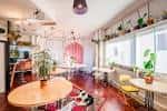 Interior luminoso del espacio comunitario con mesas redondas, plantas y decoración acogedora