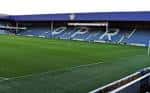 Detalle de la grada principal con el nombre 'QPR' en los asientos azules