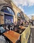 Terraza al aire libre del Hiver Taproom con mesas y clientes disfrutando