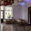 Sala decorada con globos y mesas para evento en el Our House Culture Center