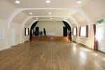 Interior del salón de eventos con suelo de madera y techo abovedado