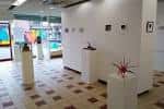 Interior del espacio expositivo con obras sobre pedestales blancos y suelo a cuadros