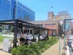 Área de comedor al aire libre en el interior de Bakery Square con personas sentadas