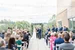 Ceremonia de boda en curso con invitados sentados mirando a la pareja