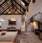 Interior del salón principal con vigas de madera expuestas y chimenea antigua
