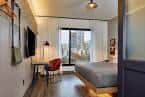 Habitación moderna con cama doble, escritorio y vista a la ciudad