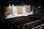 Interior del auditorio con escenario y butacas dispuestas para evento