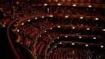 Vista panorámica del interior del auditorio con butacas rojas y balcones curvos