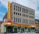 Fachada exterior del New Granada Theater en Pittsburgh con su letrero vertical amarillo