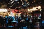 Ambiente interior del venue con luces cálidas y gente socializando
