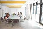 Sala de reuniones moderna con mesa larga y sillas en un espacio luminoso