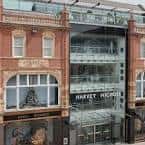 Detalle de la fachada de Harvey Nichols mostrando el rótulo y estructura de cristal