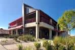 Vista exterior del WingHouse Bar & Grill con arquitectura moderna y cielo despejado