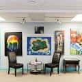 Sala de exhibición con obras de arte en las paredes y mobiliario moderno