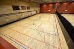 Pabellón polideportivo interior con suelo de madera y líneas de juego