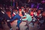 Grupo de personas patinando en círculo sobre la pista interior del establecimiento
