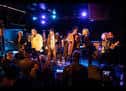 Grupo musical actuando en el escenario del The Lexington bajo luces azules