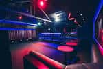 Interior del club Villa con barra iluminada en rojo y ambiente nocturno