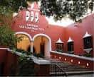 Fachada principal de la Hacienda Teya con su característica pintura roja y arcos coloniales