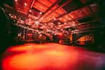 Interior del Colour Factory con iluminación roja y escenario