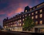 Vista nocturna del hotel iluminado con cielo al atardecer
