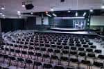 Interior del auditorio con butacas dispuestas en semicírculo y escenario