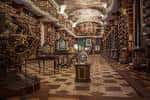 Pasillo decorado con estatuas y estanterías llenas de libros