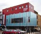Vista exterior del edificio de la casa cultural Dalston con fachada roja y cristalera azul