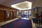 Hall de entrada con alfombra azul y mobiliario acogedor