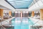 Piscina interior del hotel con techo de cristal y zonas de descanso
