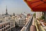 Terraza panorámica con vistas a la ciudad de Madrid y sombrillas naranjas