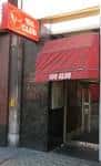 Fachada exterior del The 100 Club con letrero iluminado