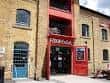 Fachada exterior del Fox ExCel con detalles en rojo y ladrillo