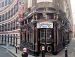 Fachada del pub The Cockpit con barra curva y detalles arquitectónicos victorianos