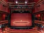 Vista frontal del escenario con cortina roja y balcones ornamentados