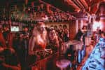 Ambiente animado en el bar con personas socializando cerca de la barra